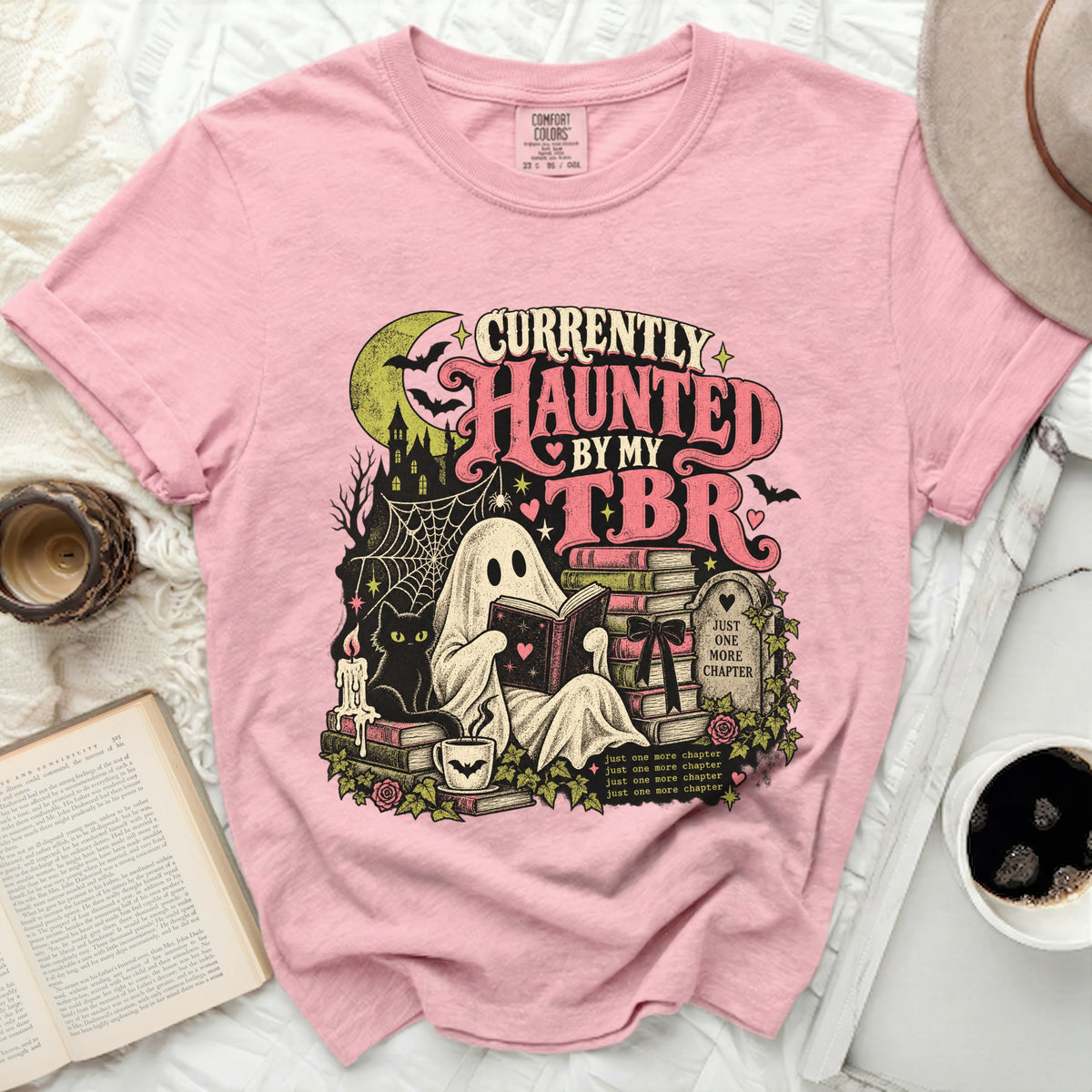 Pink t-shirt with "Currently Haunted By My TBR" graphic of a ghost reading.