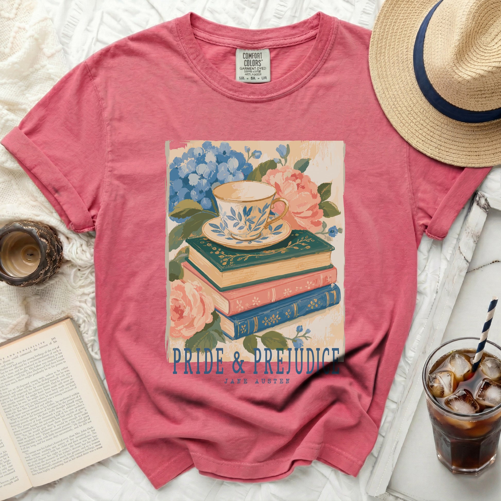 Pink t-shirt featuring "Pride and Prejudice" by Jane Austen with teacup and books graphic.
