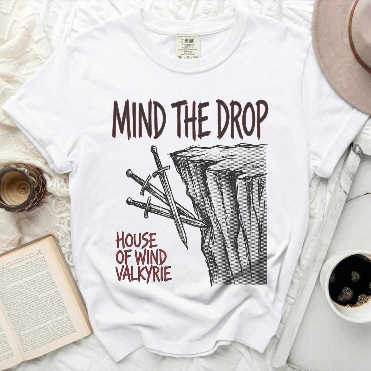 White t-shirt with "MIND THE DROP HOUSE OF WIND VALKYRIE" graphic.