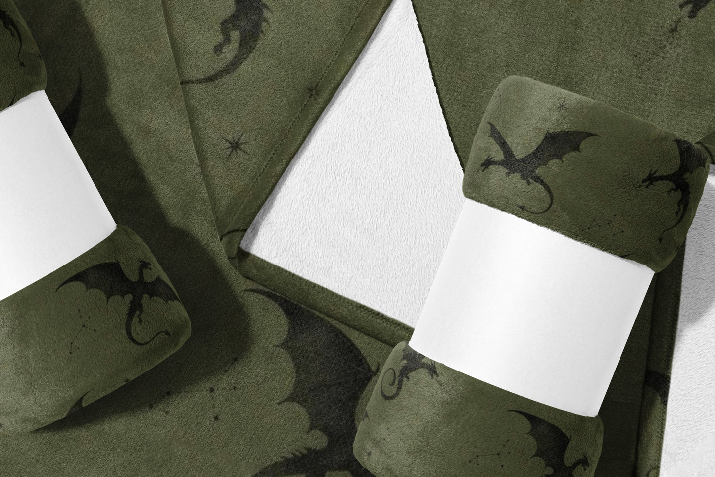 Green fleece blanket with dark dragon pattern, rolled and banded.