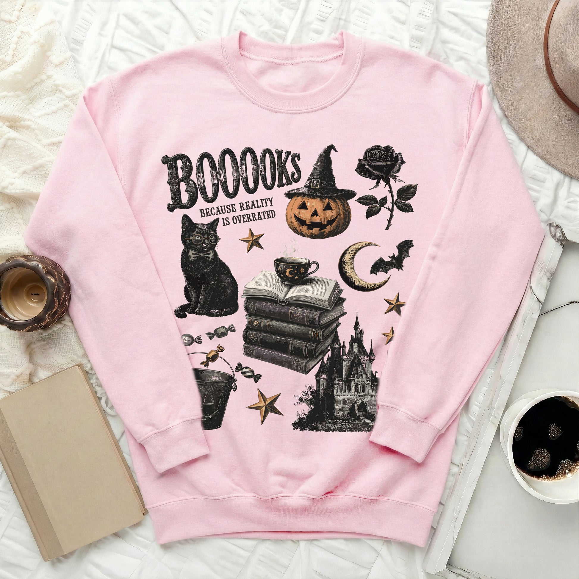 Pink sweatshirt with black Halloween-themed graphic and text: "BOOOOKS BECAUSE REALITY IS OVERRATED".