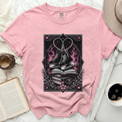 Pink t-shirt with ice skates, hearts, and stacked books graphic.