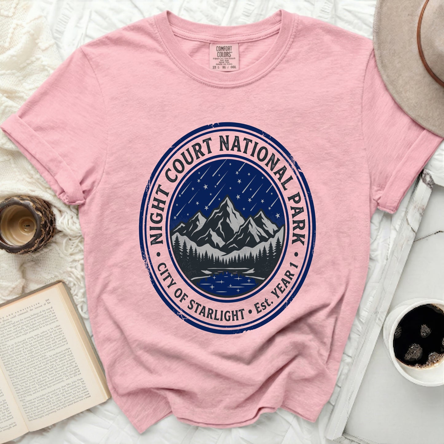 Pink t-shirt with "Night Court National Park City of Starlight Est. Year 1" circular graphic.