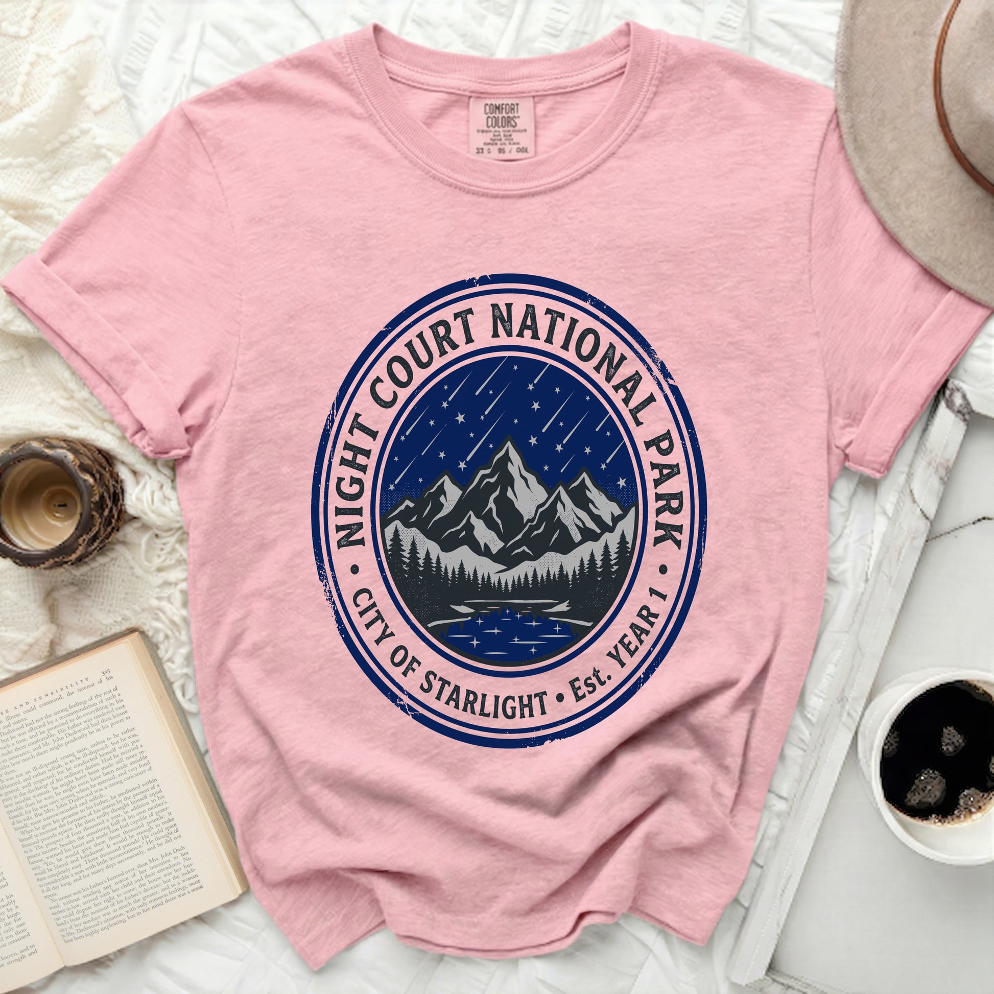 Pink t-shirt with "Night Court National Park City of Starlight Est. Year 1" circular graphic.