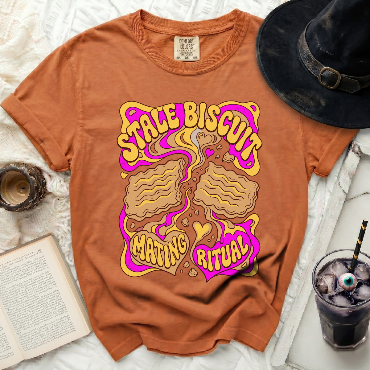 Orange t-shirt with "Stale Biscuit Mating Ritual" graphic in psychedelic style.