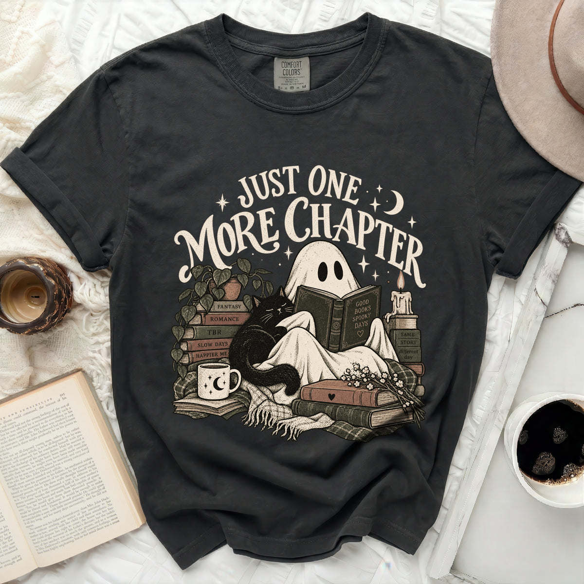 Black t-shirt with ghost reading among books and cat, "Just One More Chapter" text.