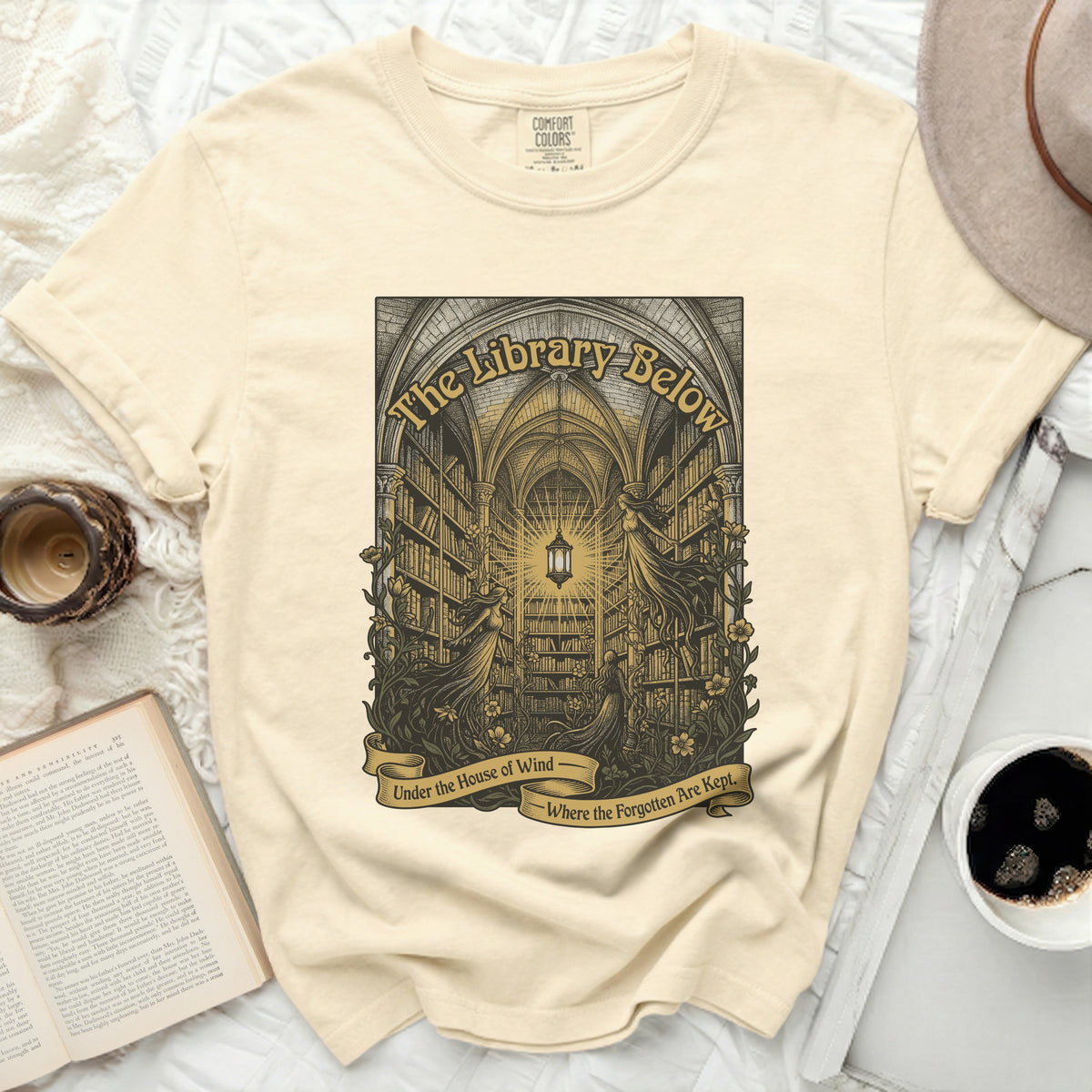 T-shirt with "The Library Below" artwork of gothic library and women.