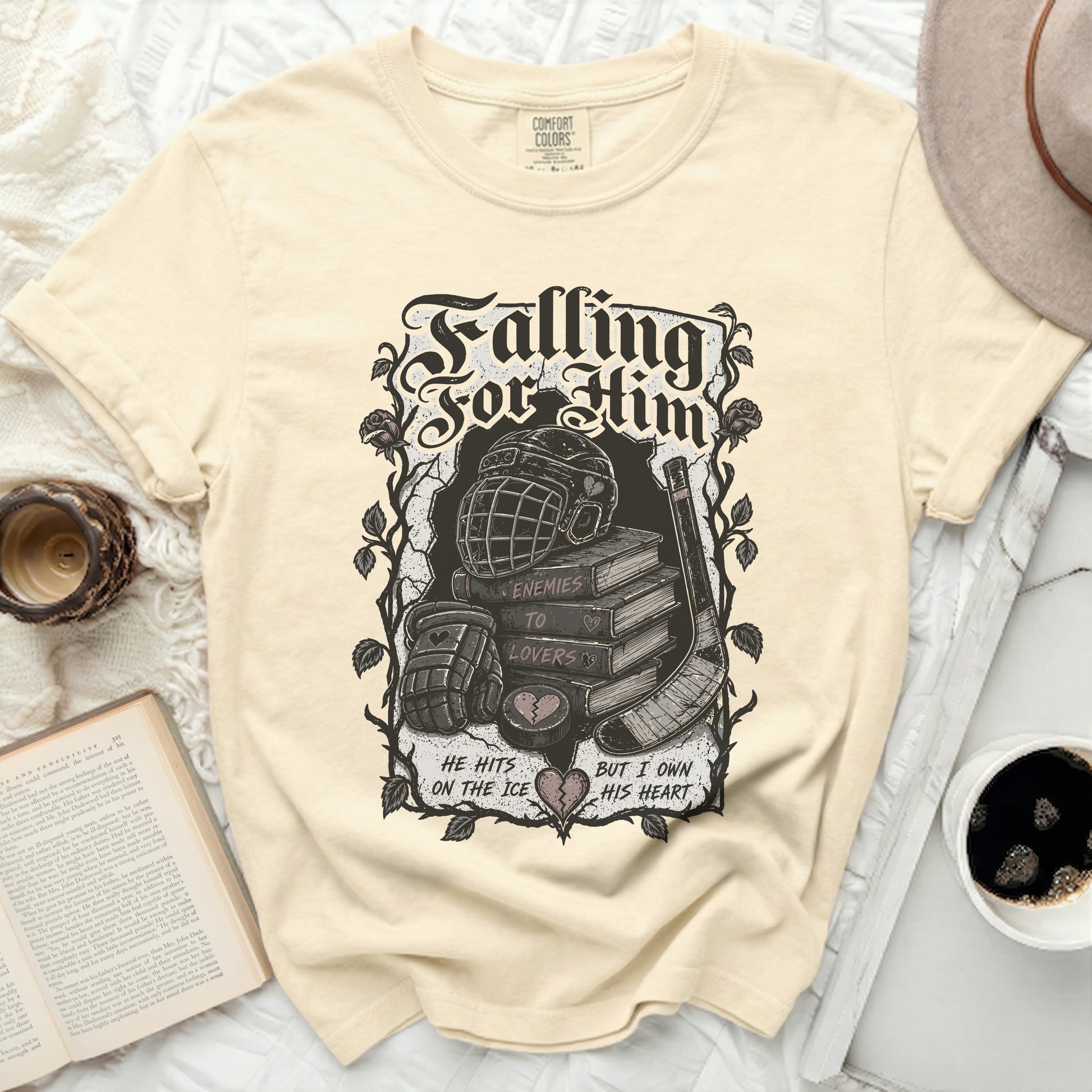 T-shirt with "Falling For Him" text, hockey gear, and books.