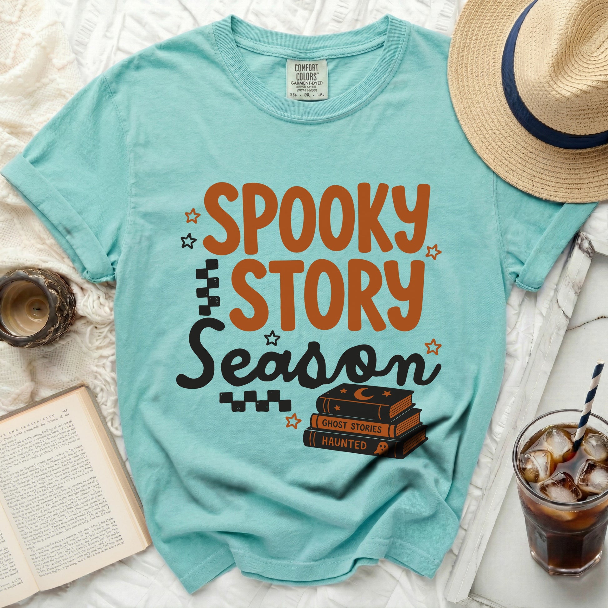 Aqua t-shirt with "Spooky Story Season" text and stacked books.