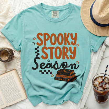 Aqua t-shirt with "Spooky Story Season" text and stacked books.