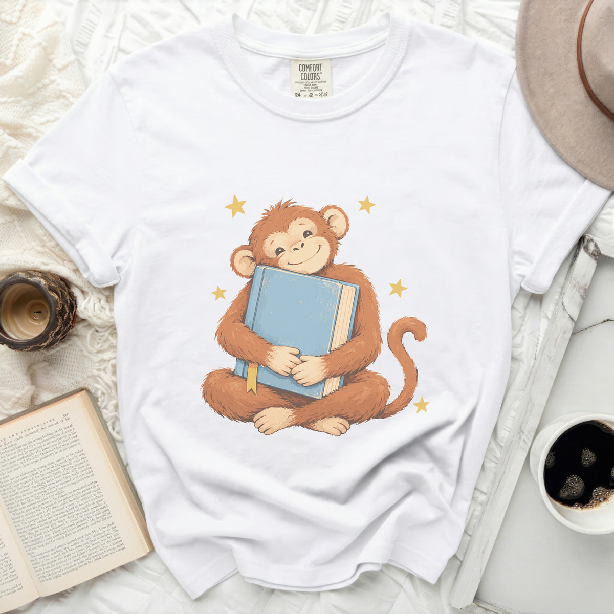 Illustration of a happy monkey hugging a blue book with yellow stars.