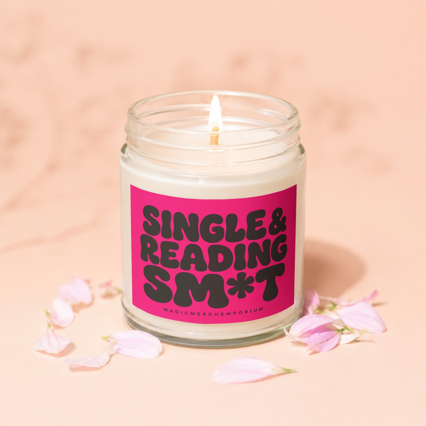 Jar candle with lit wick and pink label reading "Single & Reading Smt".