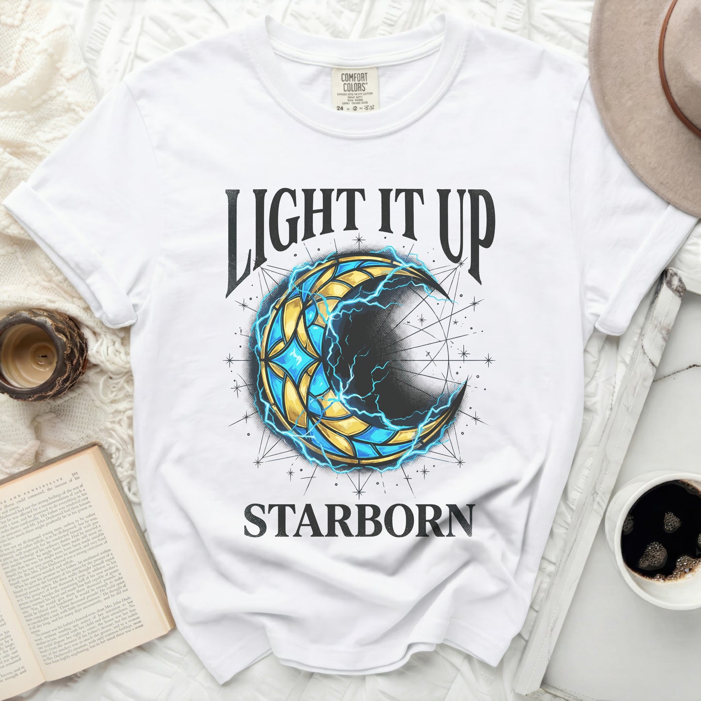 White t-shirt with "LIGHT IT UP STARBORN" graphic of a crescent moon.