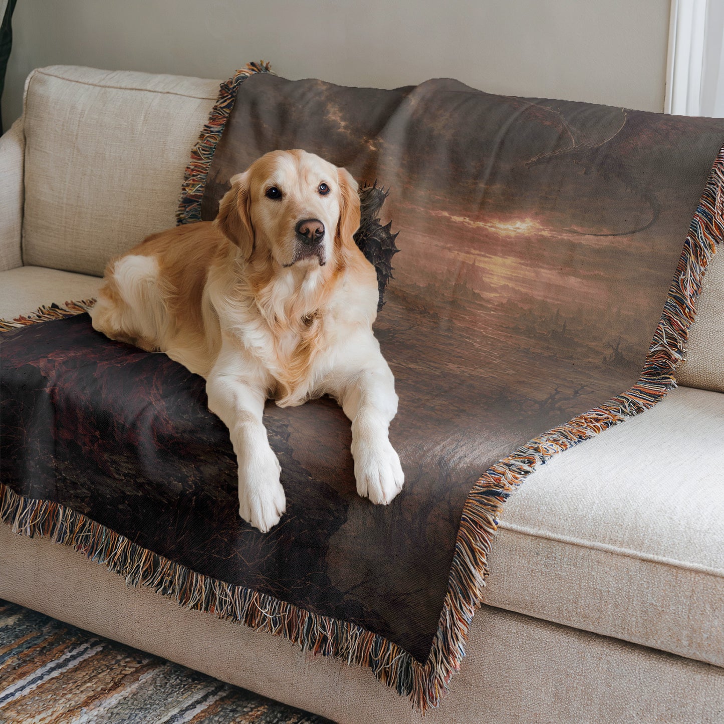 A golden retriever dog is lying on a couch, resting on a dark blanket with a landscape design.