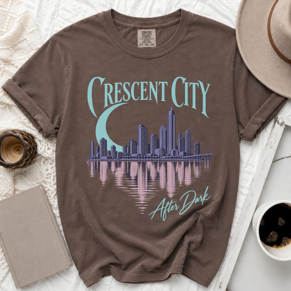 Brown t-shirt with "Crescent City After Dark" graphic featuring a skyline and moon.
