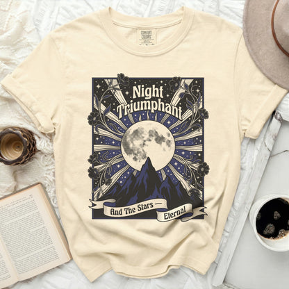 Cream t-shirt with "Night Triumphant" and celestial mountains graphic.