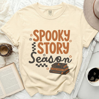 Cream t-shirt with "Spooky Story Season" graphic and stack of Halloween books.