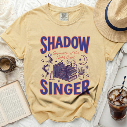 Yellow t-shirt with "Shadow Spymaster of the Night Court Singer" text and graphics.