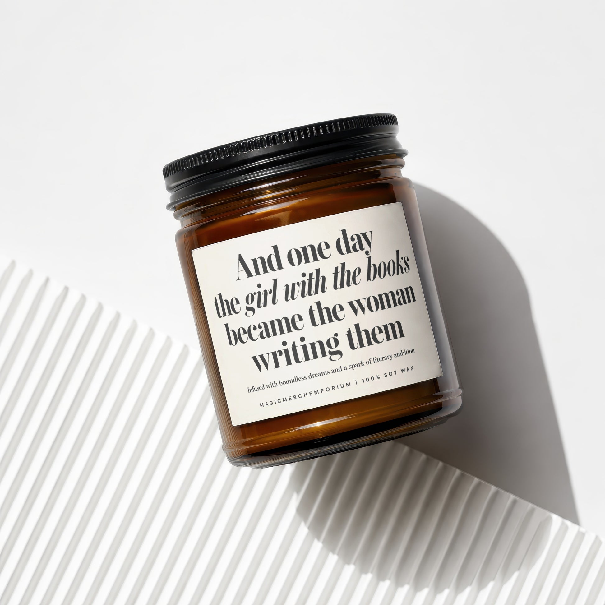 Amber jar candle with quote: "And one day the girl with the books became the woman writing them."