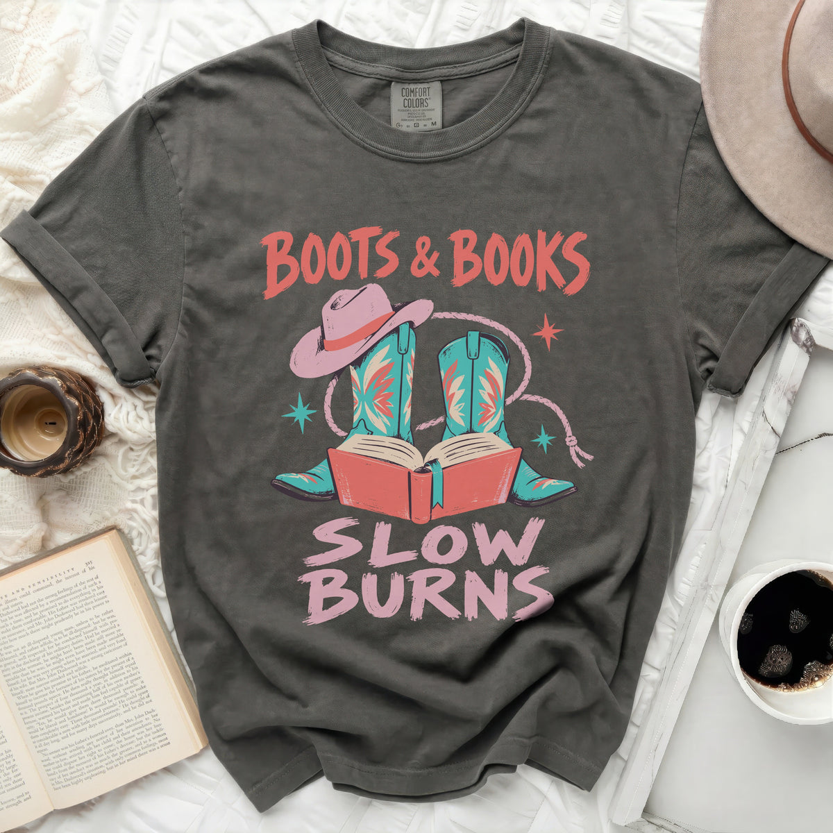 Graphic t-shirt with "Boots & Books Slow Burns" text, cowboy boots, and hat.