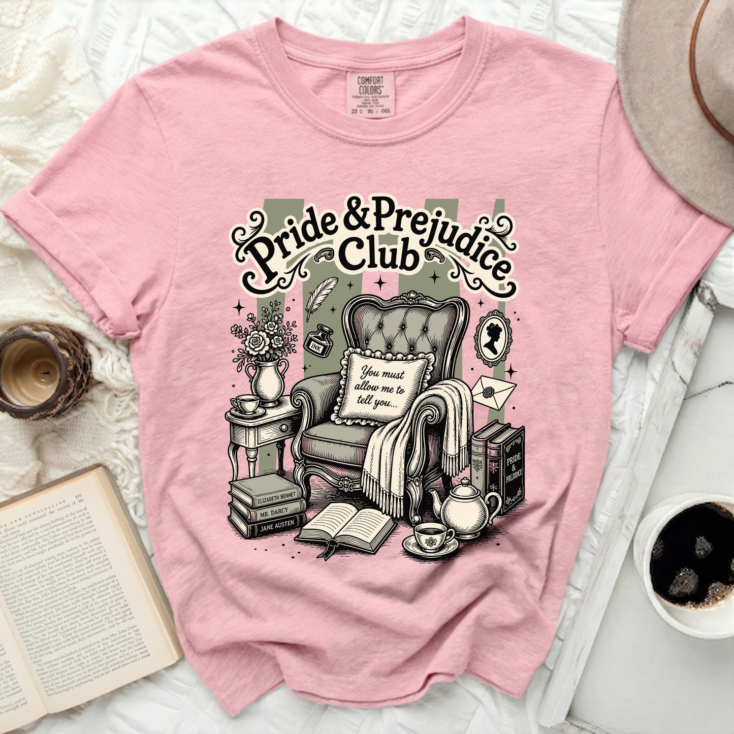 Pink t-shirt with "Pride & Prejudice Club" graphic and classic reading scene.