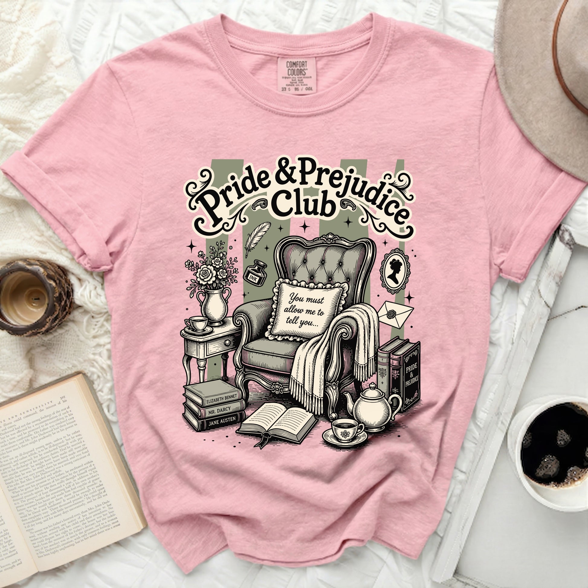 Pink t-shirt with "Pride & Prejudice Club" graphic and classic reading scene.