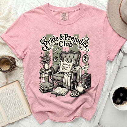 Pink t-shirt with "Pride & Prejudice Club" graphic and classic reading scene.