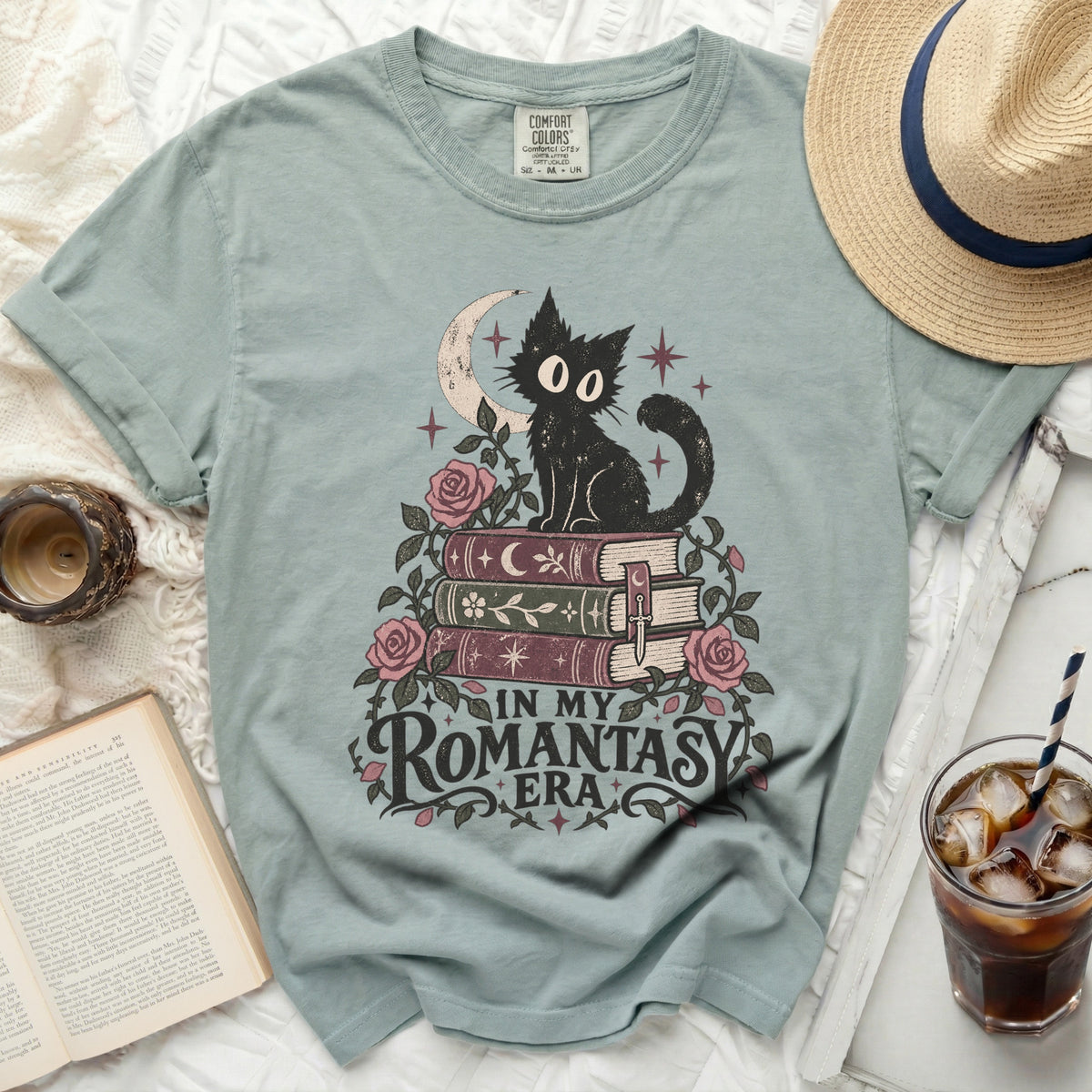 T-shirt with a black cat, crescent moon, roses, books, and text "IN MY ROMANTASY ERA".