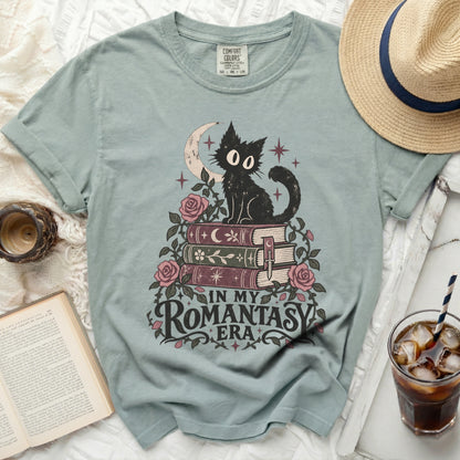 T-shirt with a black cat, crescent moon, roses, books, and text "IN MY ROMANTASY ERA".