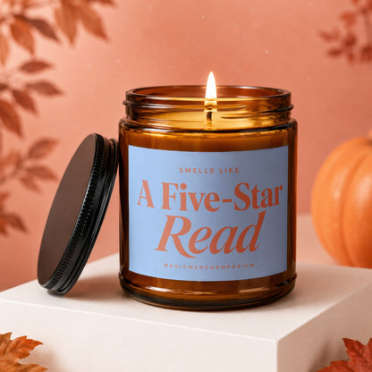 Lit amber glass candle with light blue label reading "Smells Like A Five-Star Read".
