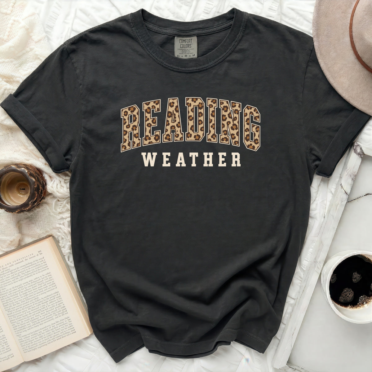 Dark gray t-shirt with "READING WEATHER" text in leopard print and block letters.