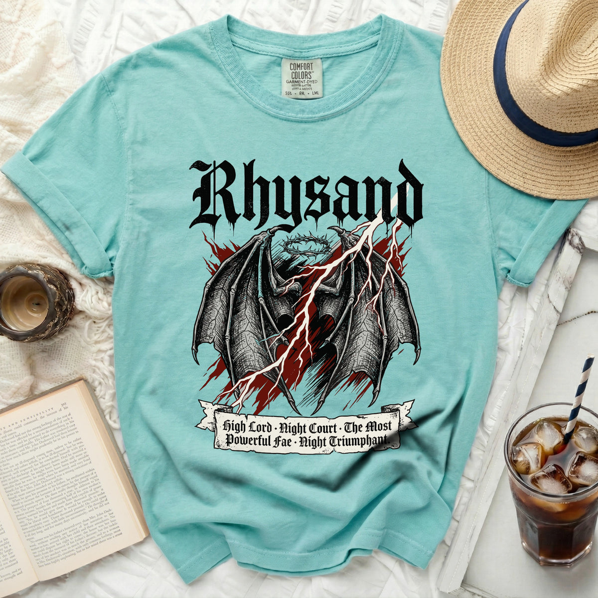 Teal t-shirt with black dragon wings, crown, and text "Rhysand" and "high lord, night court, the most powerful fae, night triumphant."
