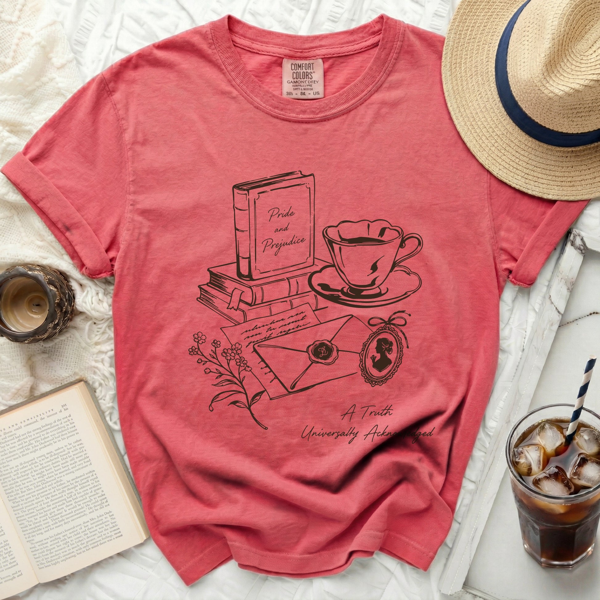 Coral t-shirt with "Pride and Prejudice" book, teacup, and letter graphic.