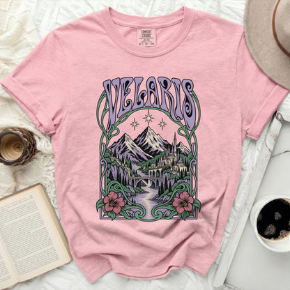 Pink t-shirt with "Velaris" in purple text above a scenic fantasy landscape.