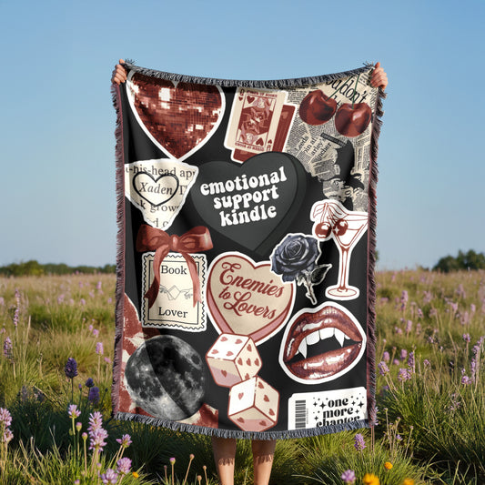 A person is holding up a blanket with various images and text on it, including a heart, a rose, a book, and other symbols.