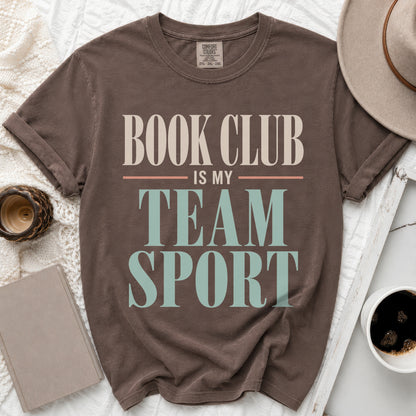 Brown t-shirt with "Book Club Is My Team Sport" text in cream and teal.