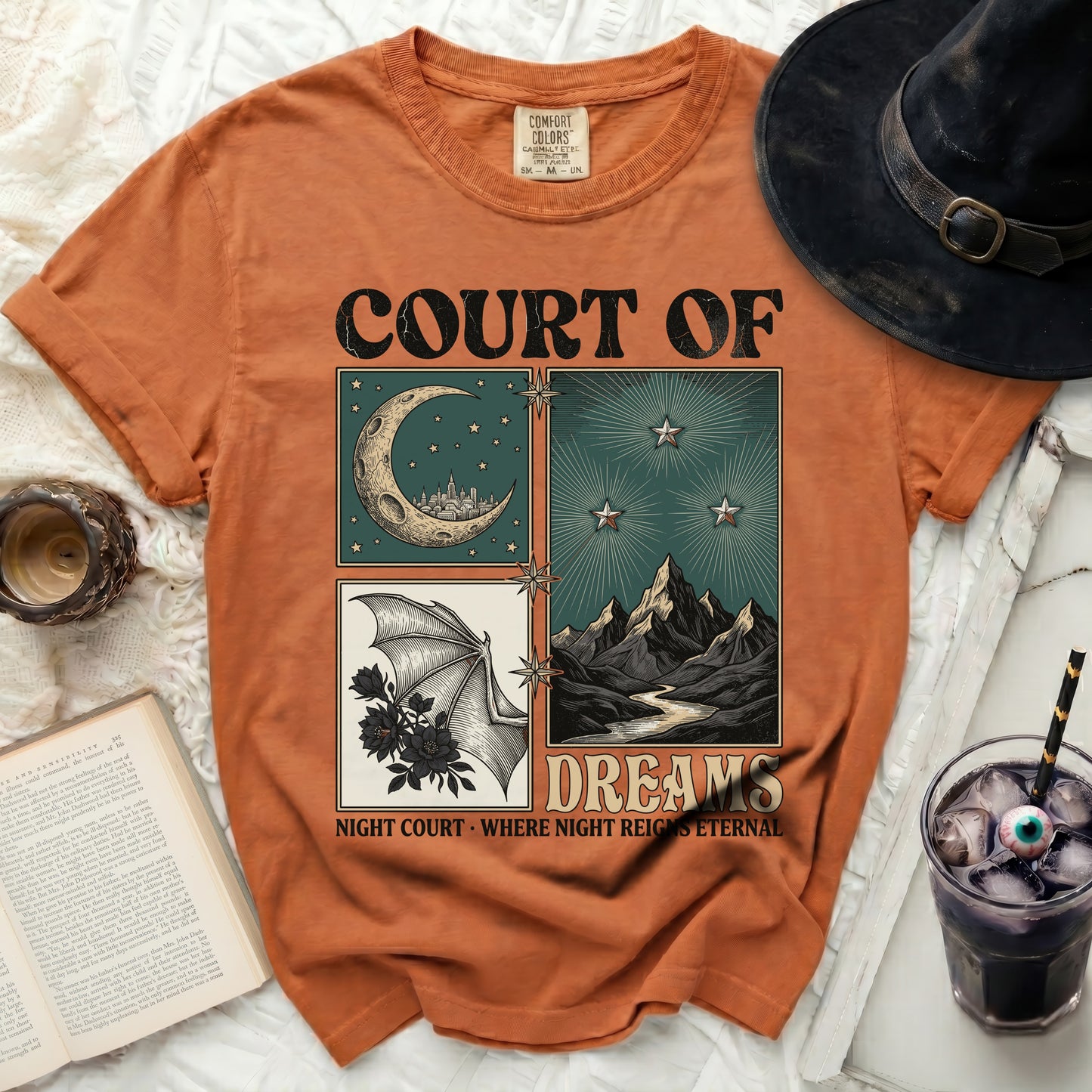 Orange t-shirt with "COURT OF DREAMS" and celestial, mountain, and bat wing graphics.