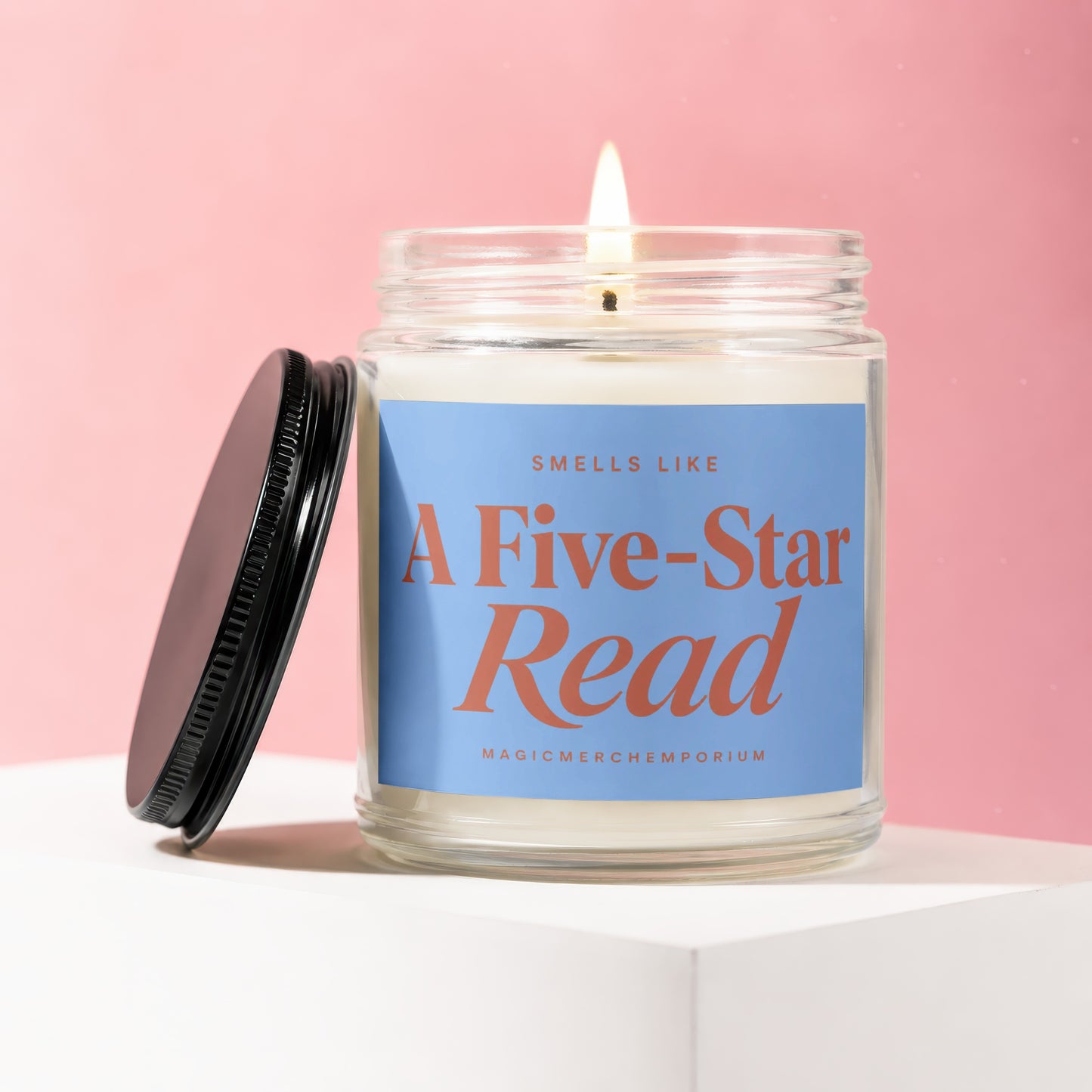 Candle with "SMELLS LIKE A Five-Star Read" on blue label, lid off.