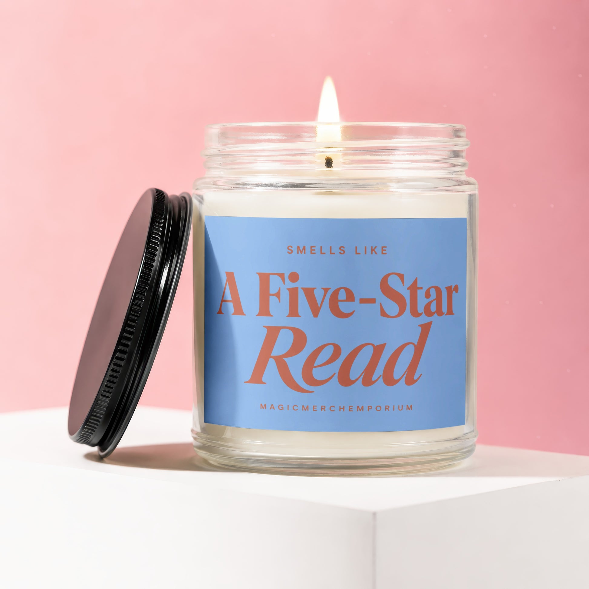 Candle with "SMELLS LIKE A Five-Star Read" on blue label, lid off.