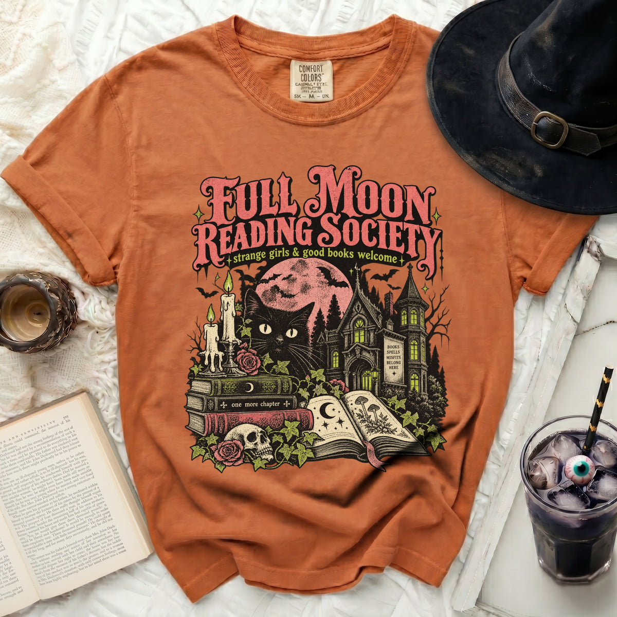 Orange t-shirt with "Full Moon Reading Society" graphic featuring a black cat and spooky house.
