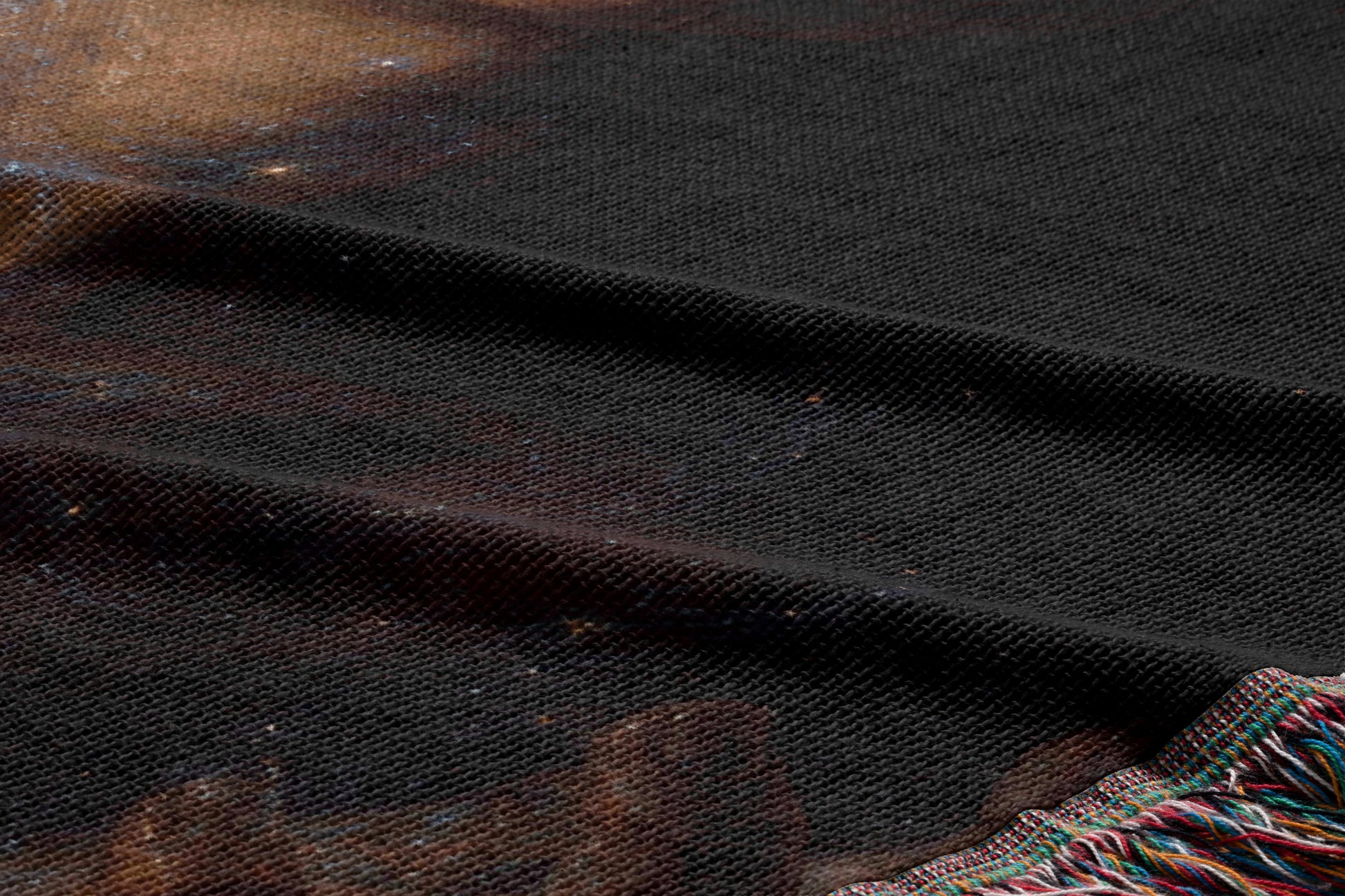 a close-up view of a dark fabric with a textured surface, possibly a blanket or textile.