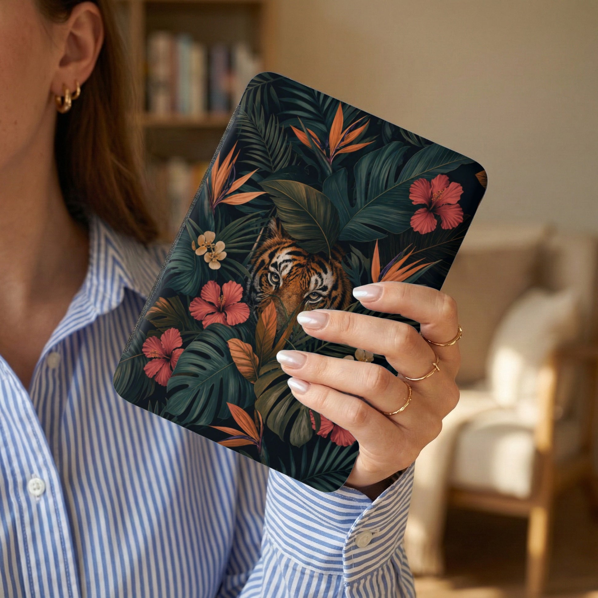 Device case with tiger and tropical foliage print, held by a person.