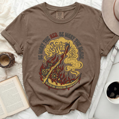 Brown t-shirt with "Be Wary the Red, Be Wary the Blade" and scythe graphic.