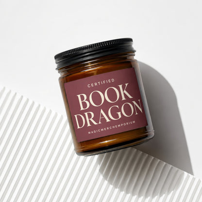 Amber jar candle titled "Certified Book Dragon" from MagicMerchEmporium.