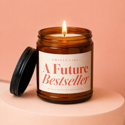 Amber glass candle with lit wick and lid nearby, reads "Smells Like A Future Bestseller".
