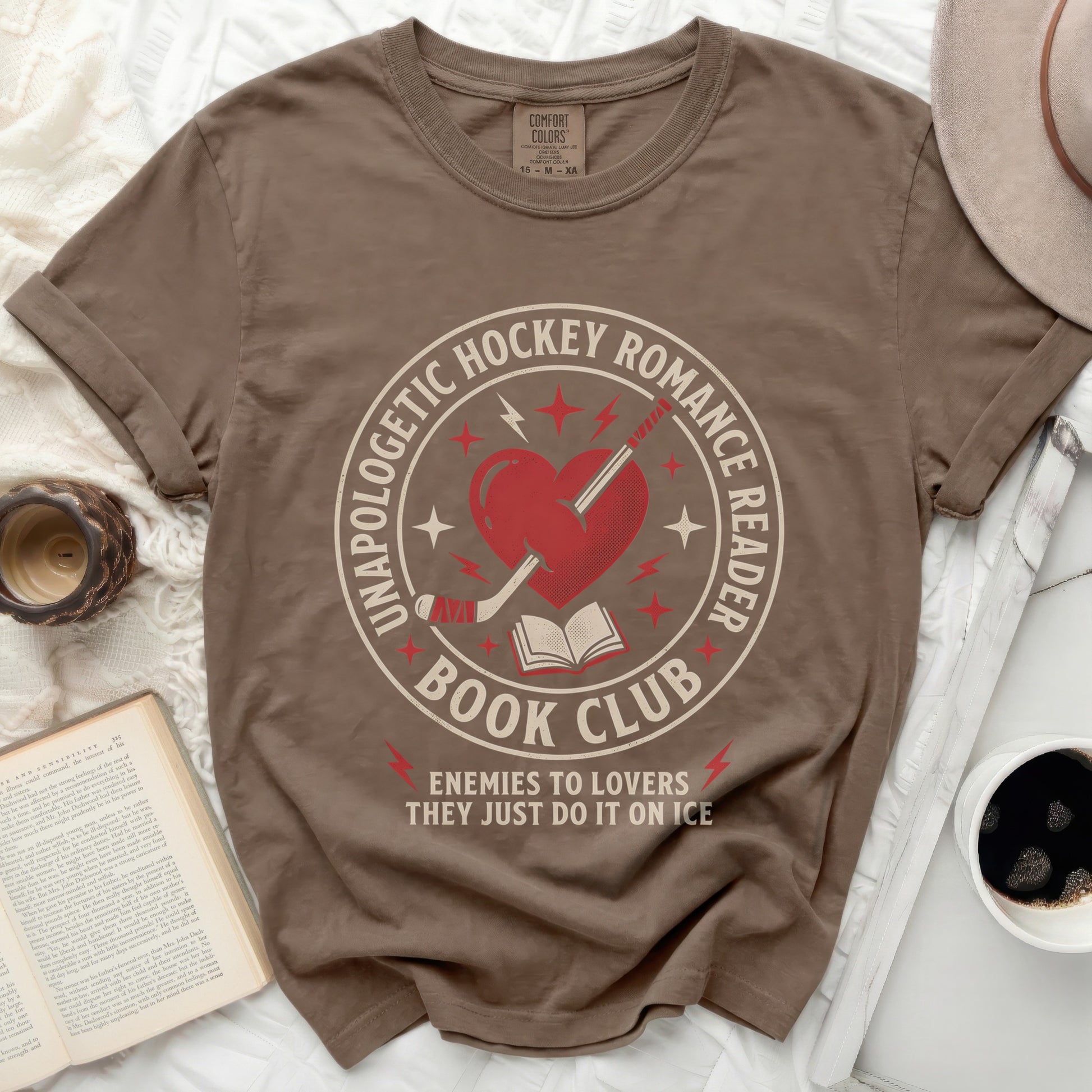 Brown t-shirt with "Unapologetic Hockey Romance Reader Enemies to Lovers" book graphic.