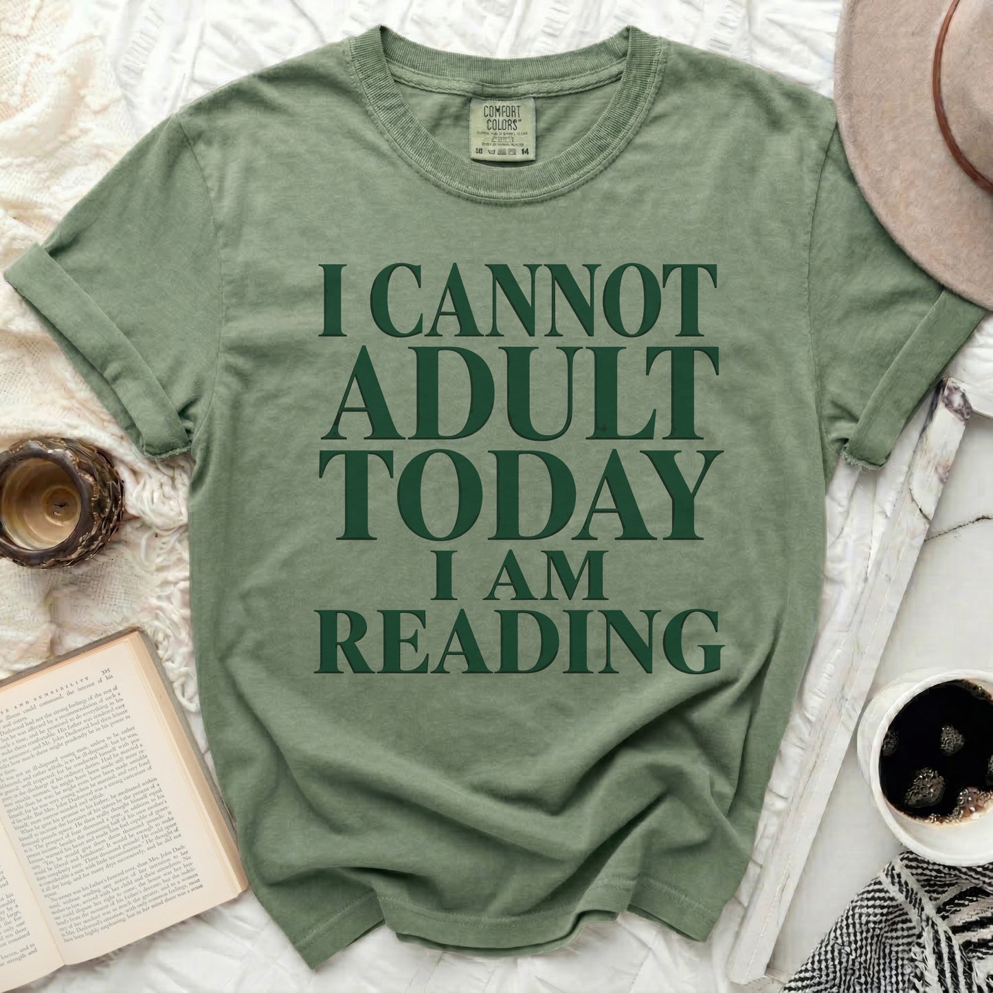 Green t-shirt with "I Cannot Adult Today I Am Reading" text.