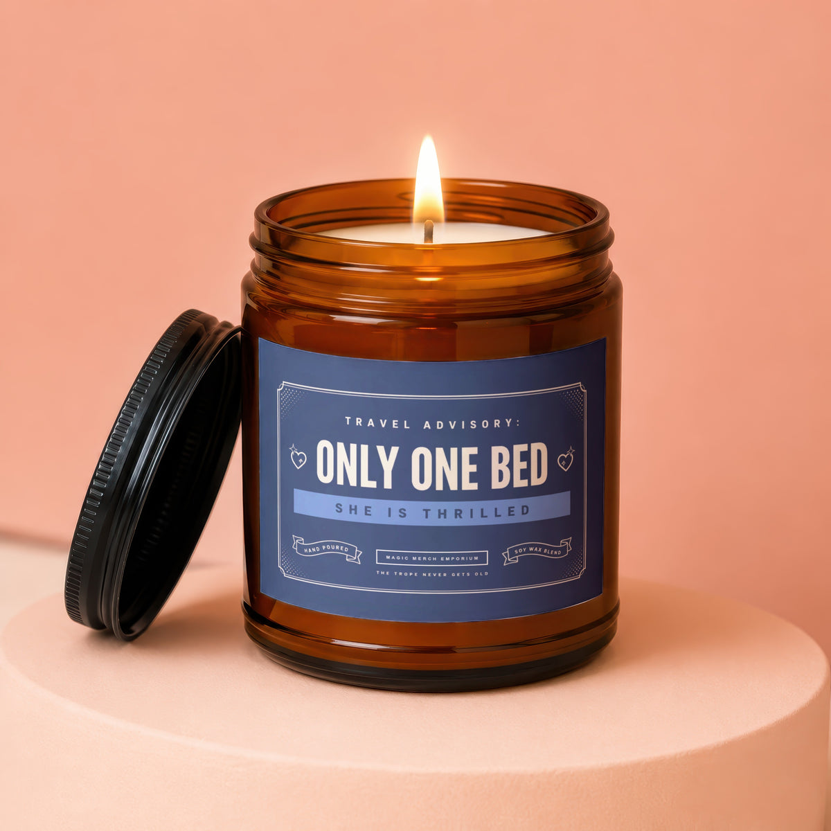 Amber jar candle with lit wick and lid off, reads "Only One Bed"