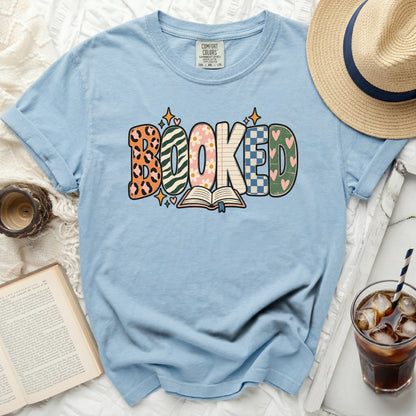 Light blue t-shirt with "BOOKED" graphic and an open book.