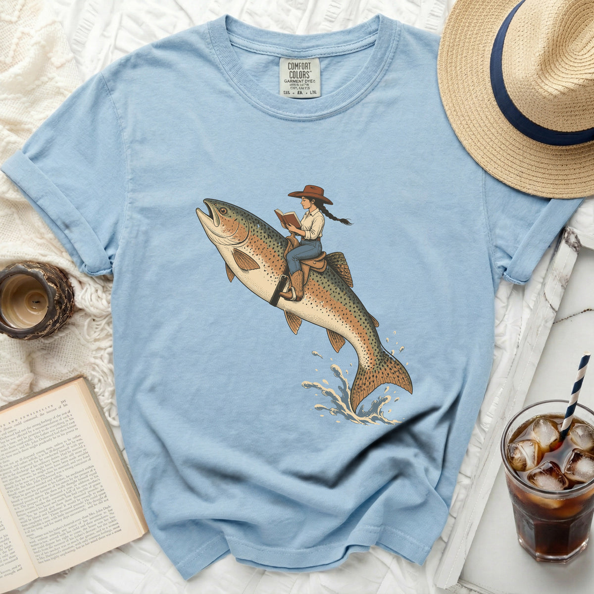 Woman riding a trout, reading a book, with text on shirt label.